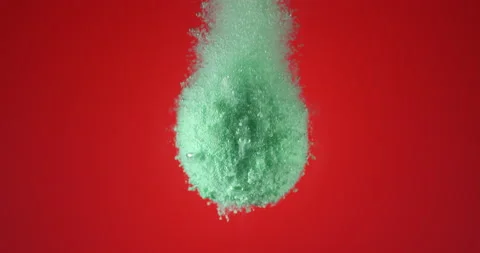 Mint color bath bomb falling down into clean water against red background 動画素材 152687981