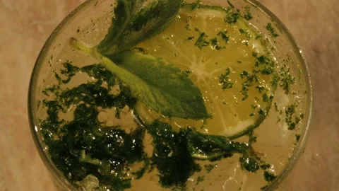 Mint falling down on mojito with ice in glass Stock Footage 155791865