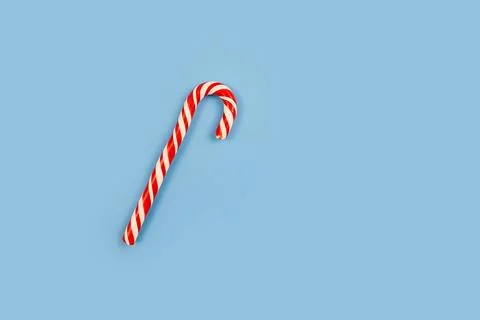 Mint hard candy cane striped in Christmas colours on blue background. Closeup Stock Photos