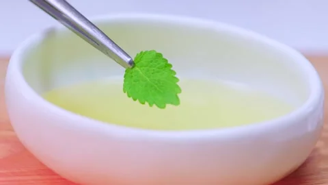 The mint leaf is falling into the oil Stock Footage 133021552