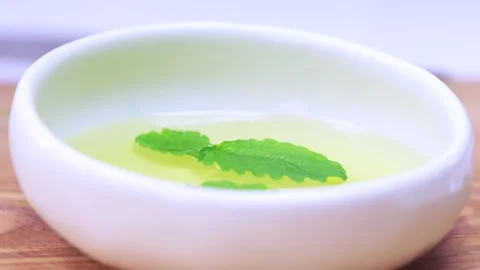 The mint leaf is falling into the oil. Stock Footage 136878536