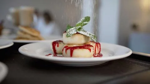 A mint leaf is placed on the cheesecakes. Close-up of cheesecakes with powd.. Foto stock