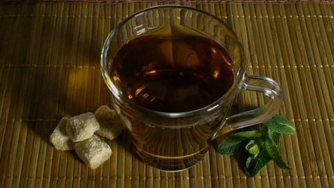 Mint leaves in a cup of tea turn around 스톡 동영상 73277709