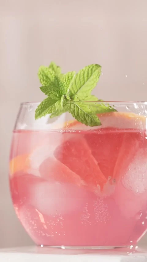 Mint leaves falling into a glass of refreshing lemonade, close up. Stock Footage 311004199