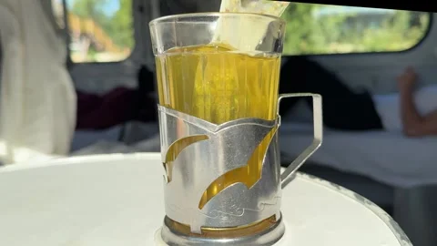 Mint tea drink from glass cup on train with iron mug stand Stock Footage 316077796
