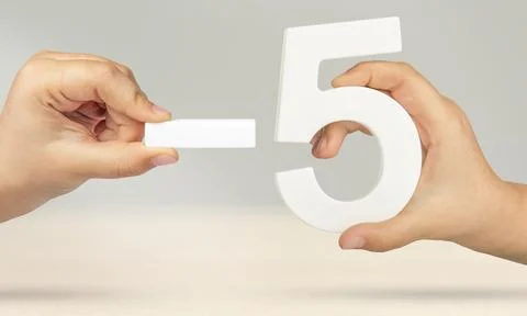 Minus five. The number five and the minus symbol in a hand close-up on a light Stock Photos