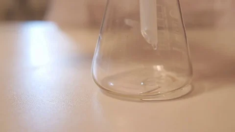 From the minzurka drips liquid into the flask Stock Footage 74578797