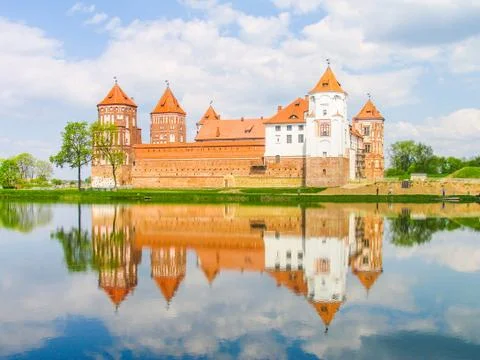 Mir, Belarus. Castle Complex Mir reflected in lake On Sunny Day with blue sky Stock-Fotos
