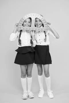 Mired in geometry. Maths and geometry. Kids in uniform at yellow wall Stock Photos