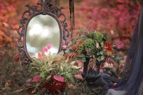 Mirror and table with decorations in the forest with fallen leaves Stock Photos