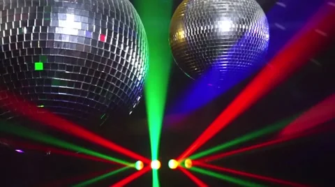Mirror balls rotate and reflect lights of projectors breaking through smoke at Video stock 68152000