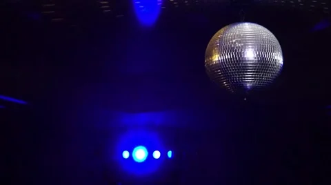 Mirror balls rotate and reflect lights of projectors breaking through smoke at Video stock 68289130