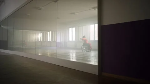 Mirror in the dance studio with a reflection of a dancer dancing in a wheelchair Video stock 290325023
