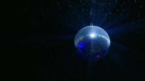 Mirror Disco Ball Rotating with Bright Blue Light Rays on Black Background Stock Footage 334593468