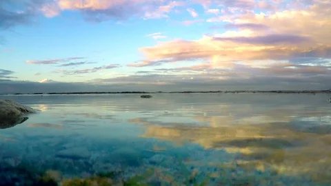  mirror effect of sunset sky with clouds and sea waves Stock Footage 89607568
