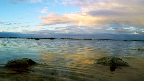  mirror effect of sunset sky with rainbow and sea waves Stock Footage 89322866