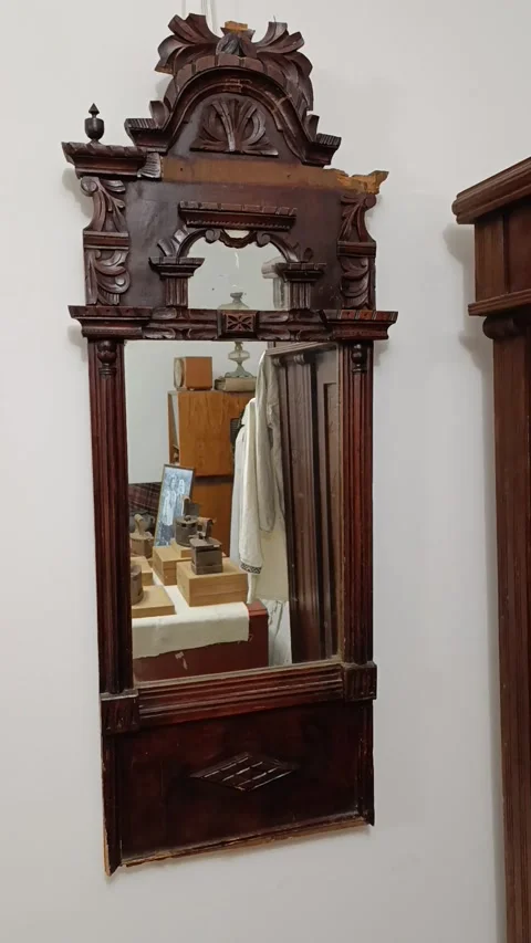 A mirror hanging on a wall next to a shelf Stock Footage 293510146