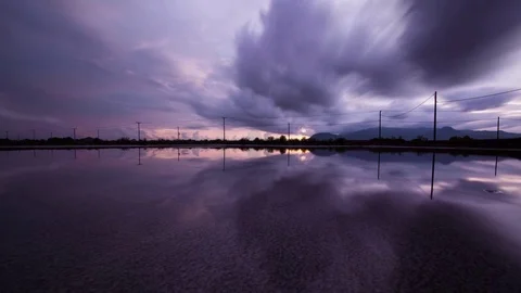 Mirror image cloud reflections and sunset on the salt fields of the south east Stock Footage 79316338