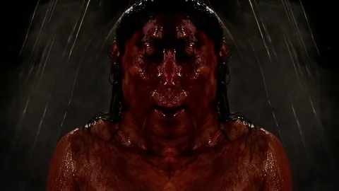 Mirror image of rain pouring on bloody person Stock Footage 99073751