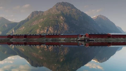 Mirror image right to left pan aerial of red huts in harbour in Norway Stock Footage 100349744