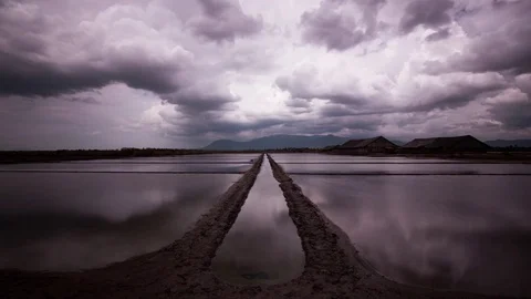 Mirror image storm clouds reflections on the salt fields of the south east Asia Stock Footage 79314928