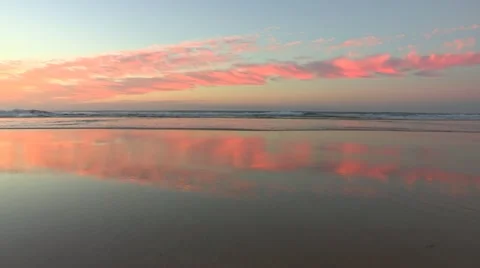 Mirror image sunrise clouds over beach Stock Footage 11131048