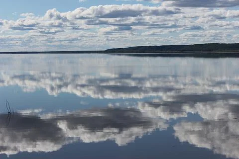 Mirror lake with reflection of white clouds overlooking the coast Stock Photos