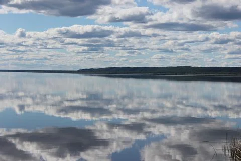 Mirror lake with reflection of white clouds overlooking the coast Stock Photos
