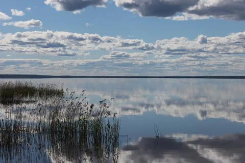 Mirror lake with reflection of white clouds overlooking the coast Stock Photos