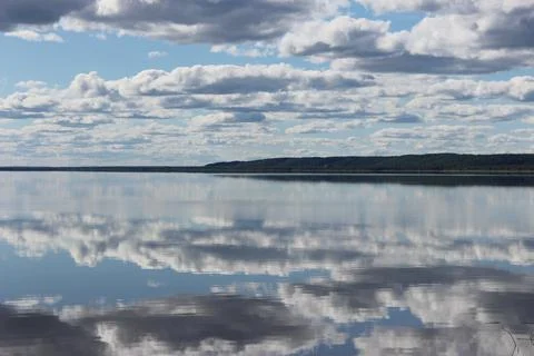 Mirror lake with reflection of white clouds overlooking the coast Stock Photos