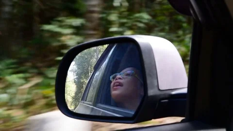 Mirror of little boy in the car while on drive Stock Footage 72975161