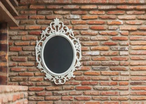 The mirror on the old brick wall Stock Photos