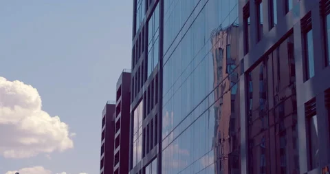 Mirror reflection in the glass surface of a skyscraper, neighboring buildings Stock Footage 119614569