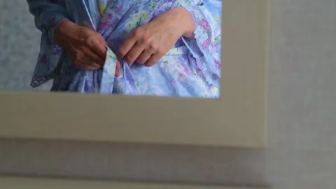 Mirror reflection of hands tie the belt, close-up. Female morning. Stock Footage 246484210