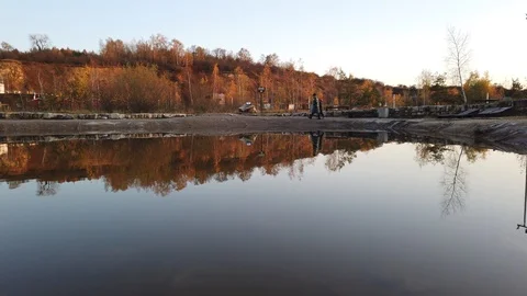 Mirror reflection of mother and son who walks along the lake in autumn Stock Footage 119786441