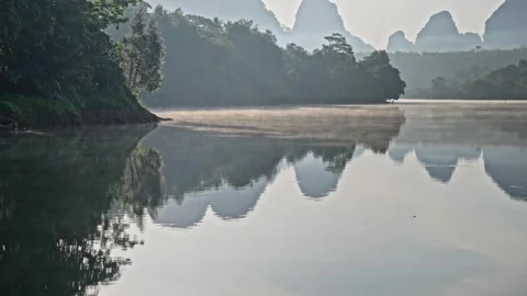 Mirror river trees mountains, calm flow of water, sun rays through the fog Stock Footage 254281425
