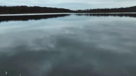 The mirror surface of the lake and the reflection of the cloudy sky. Video stock 69076772