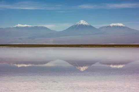 Mirror surface of mountain lake surrounded by high peaks Stock Photos