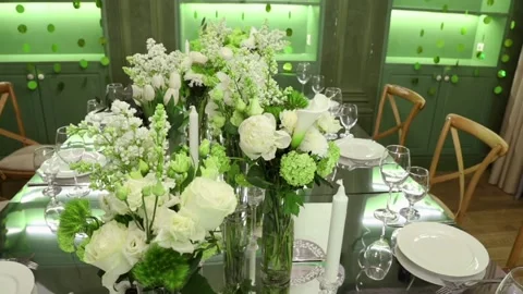 Mirror table, candles, glass vases with white roses, chrysanthemums, tulips Stock Footage 131180682