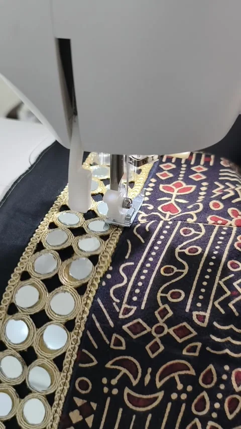 Mirror work embroidery is getting stitched on ajrak fabric on sewing machine Stock Footage 313533131