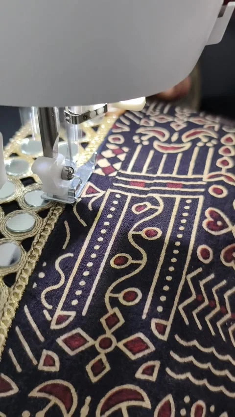 Mirror work embroidery is getting stitched on ajrak fabric on sewing machine Stock Footage 313533144
