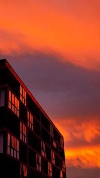 Mirrored building completely red with the reflection of the sunset light Stock Photos