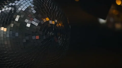 A mirrored disco ball in close-up rotates at a party. Rays of different colors Stock Footage 163743107