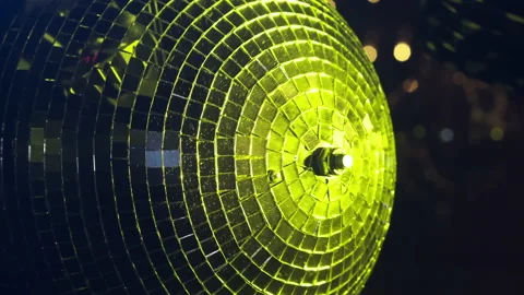 A mirrored disco ball in close-up rotates at a party. Rays of different colors Stock Footage 165516956