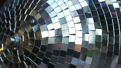 A mirrored disco ball in close-up rotates at a party. Rays of different Video stock 274062042