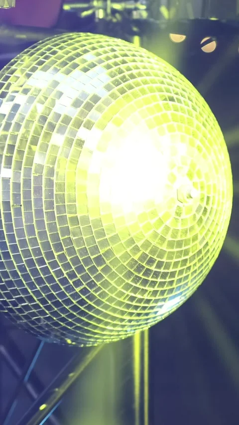 A mirrored disco ball in close-up rotates at a party. Rays of different col.. Stock Footage 306146901