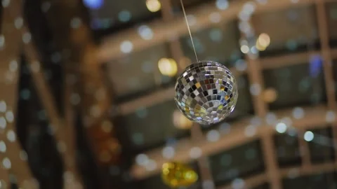 A mirrored disco ball suspended from the ceiling inside a high-rise building. Stock Footage 169410882