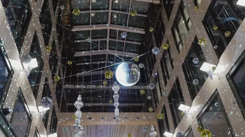 A mirrored disco ball suspended from the ceiling inside a high-rise building. Stock Footage 169844814