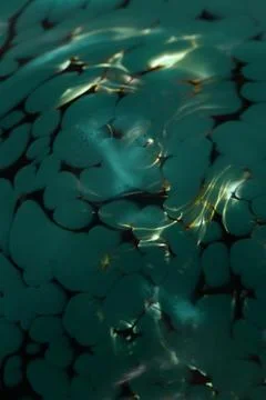 A mirrored gray pattern from a closeup of fluids creates a peaceful background Stock Photos
