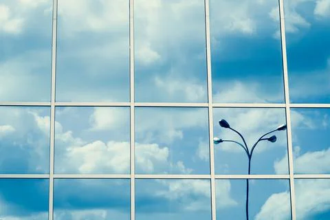 Mirrored windows, reflection of clouds and lantern, blue sky, skyscraper surf Stock Photos